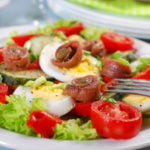 plato de ensalada con anchoas tomate y huevo